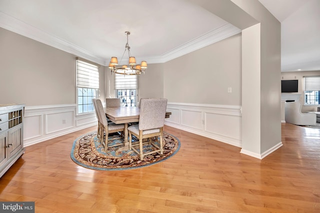 dining area featuring light hardwood / wood-style floors, a healthy amount of sunlight, and crown molding