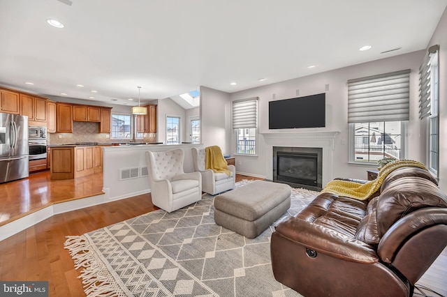 living room with a skylight and hardwood / wood-style floors