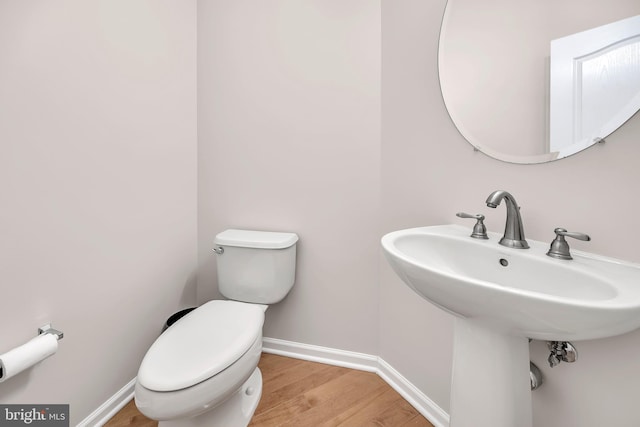 bathroom with hardwood / wood-style floors and toilet