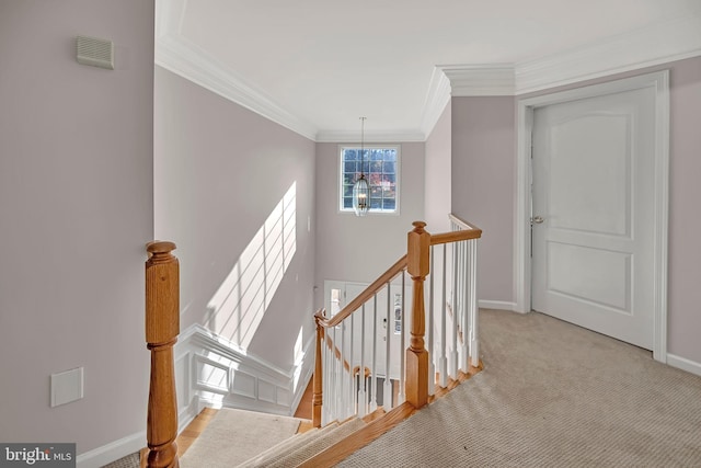 stairway with carpet, a notable chandelier, and crown molding