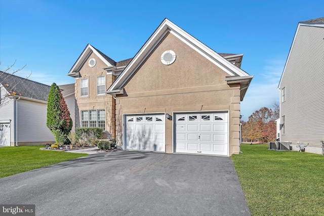 view of front property with a front lawn, a garage, and central AC