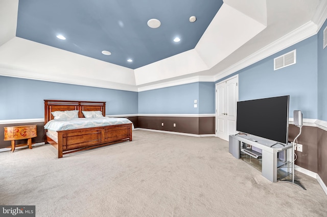 carpeted bedroom with a raised ceiling and crown molding