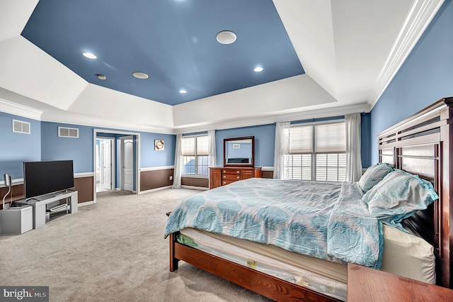 bedroom with a tray ceiling, light carpet, and ornamental molding