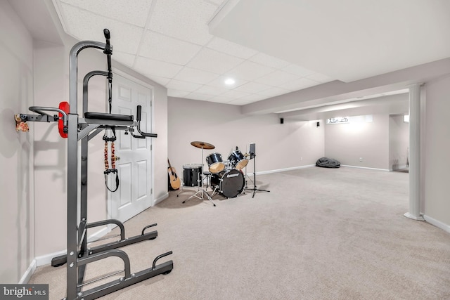 workout room with a paneled ceiling and light carpet