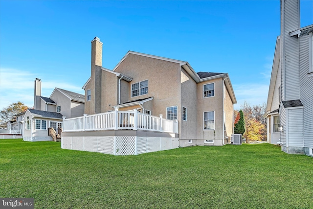 rear view of property featuring central AC, a yard, and a deck