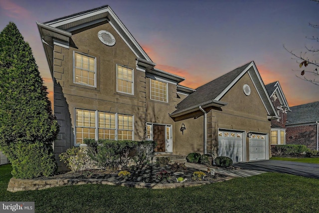 view of property featuring a lawn and a garage