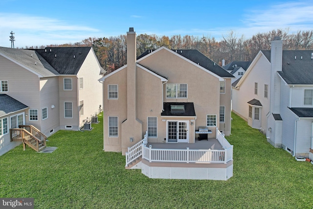 rear view of house featuring a deck and a yard