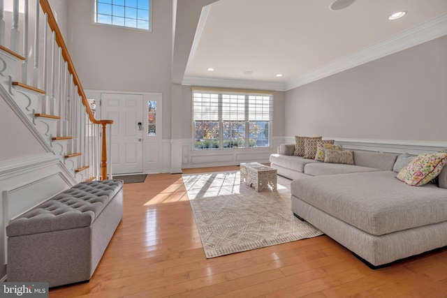 living room featuring light wood-type flooring and crown molding