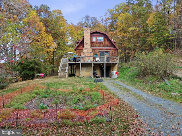 831 Stephens Ln, Fort Valley, VA 22652 - back of property featuring stairway, a deck, a chimney, a vegetable garden, and driveway