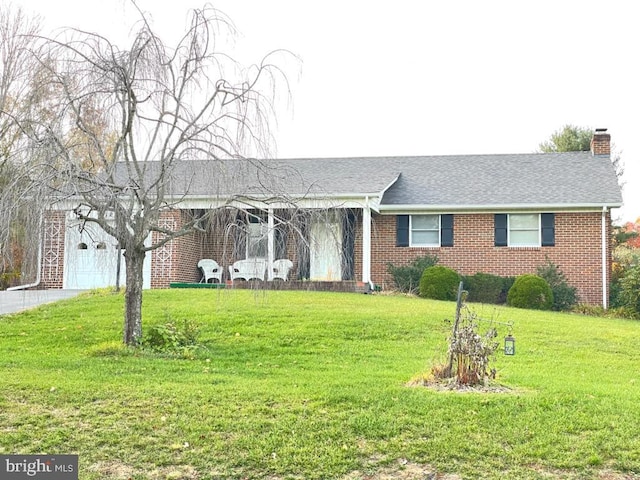 ranch-style house featuring brick siding, a chimney, and a front yard