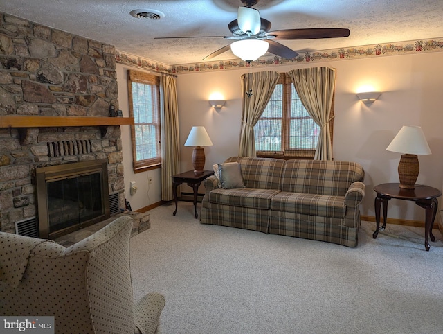 living room with a textured ceiling, carpet flooring, and a healthy amount of sunlight