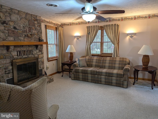 living area with a textured ceiling, visible vents, ceiling fan, carpet flooring, and baseboards