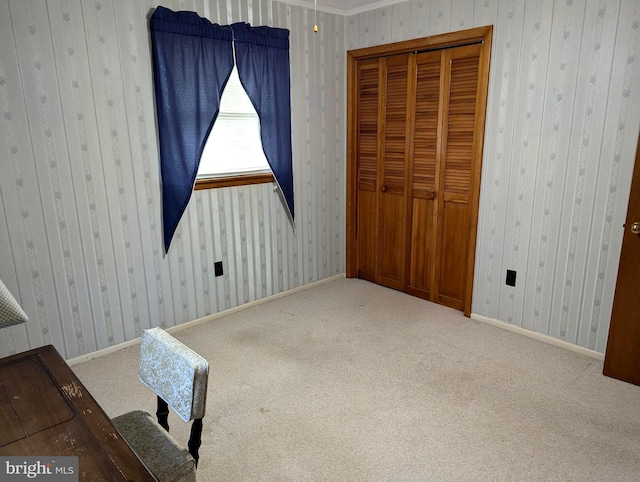 unfurnished bedroom with a closet, crown molding, and carpet