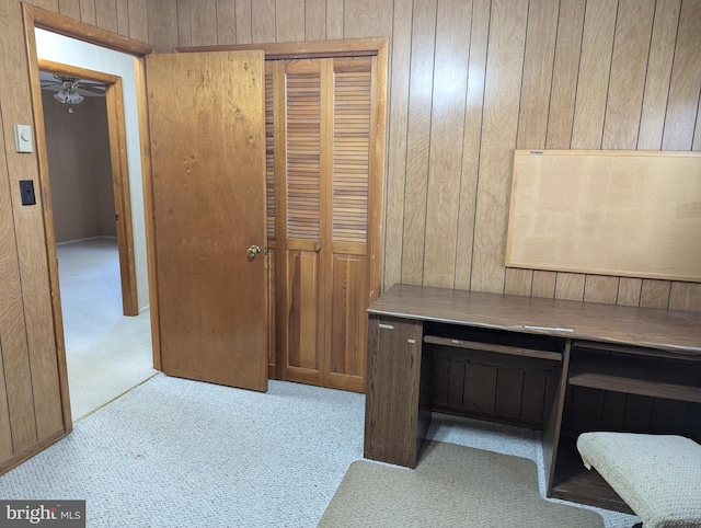 office area featuring wood walls and light carpet