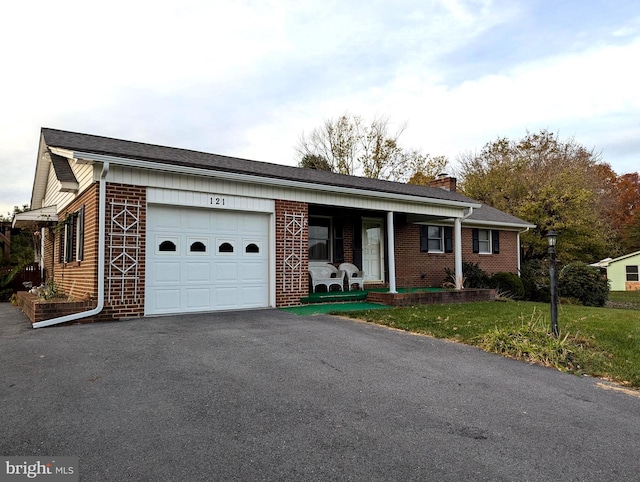 ranch-style house with an attached garage, covered porch, a chimney, aphalt driveway, and brick siding