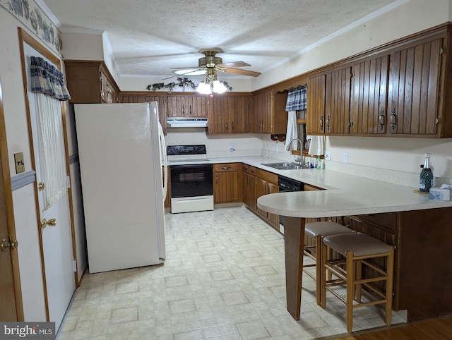 kitchen with a textured ceiling, white appliances, sink, kitchen peninsula, and ceiling fan