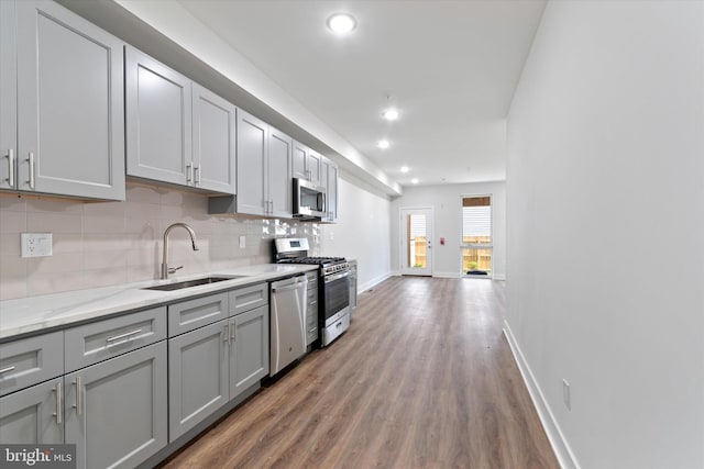 kitchen featuring stainless steel appliances, gray cabinetry, sink, and hardwood / wood-style floors