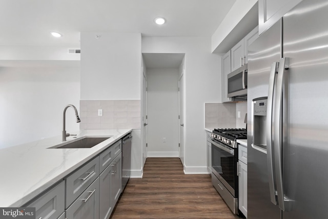 kitchen featuring appliances with stainless steel finishes, tasteful backsplash, sink, and dark hardwood / wood-style floors