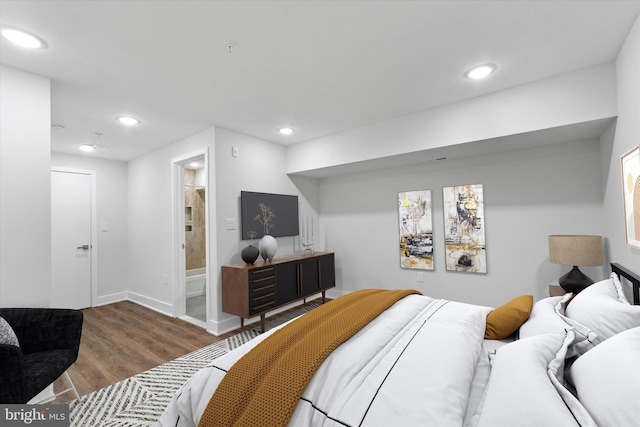 bedroom with ensuite bath and hardwood / wood-style flooring