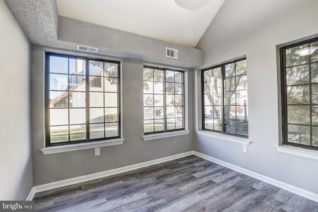 empty room with hardwood / wood-style floors and a wealth of natural light