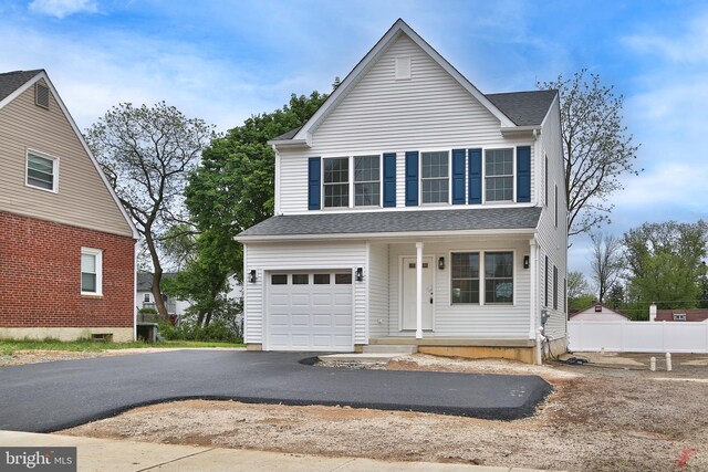 view of property featuring a garage and covered porch