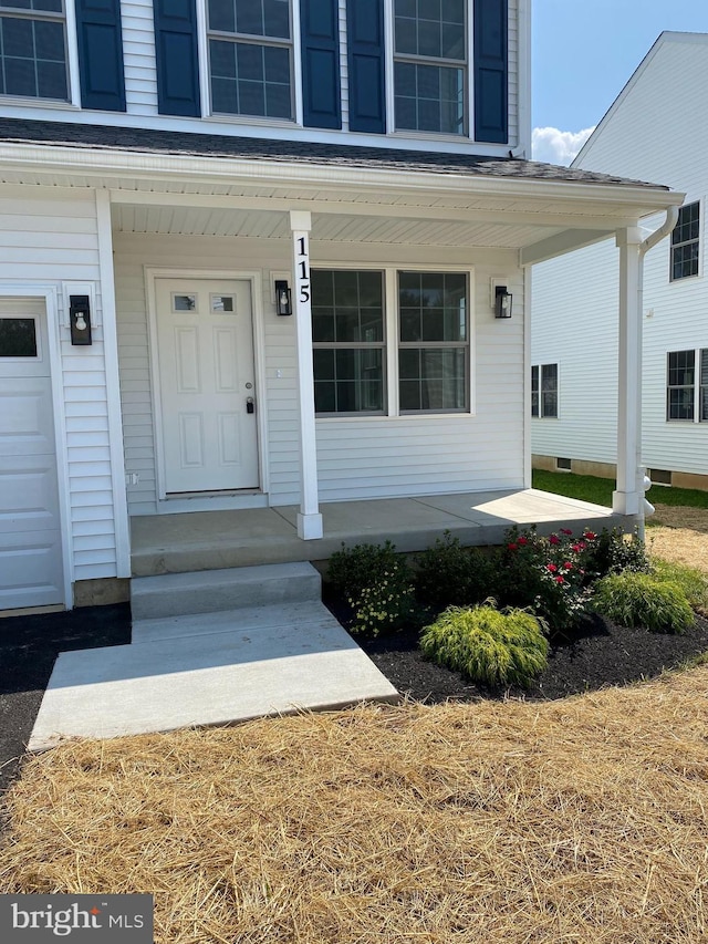 property entrance featuring a porch and a garage