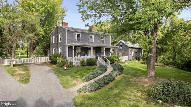 view of front facade featuring covered porch and a front lawn