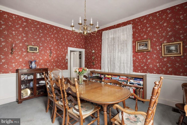 dining area featuring crown molding, carpet floors, and a notable chandelier