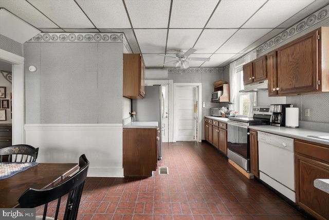 kitchen with ceiling fan, a drop ceiling, and stainless steel appliances