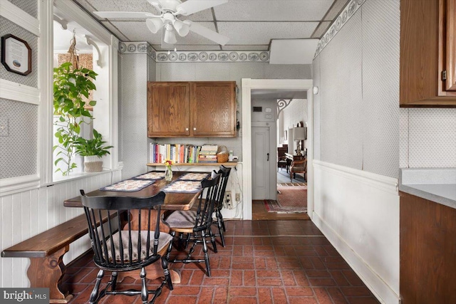 dining area with a paneled ceiling and ceiling fan