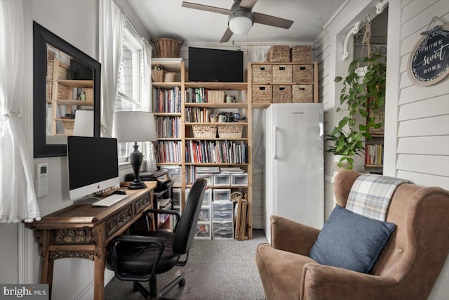 office with carpet flooring, wood walls, crown molding, and ceiling fan