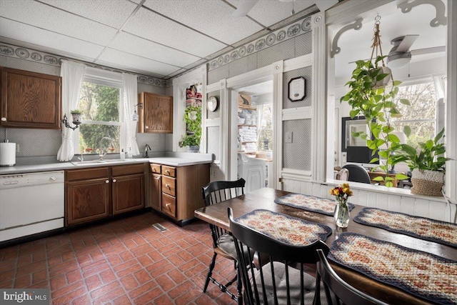 355 Orchard Dr, Mount Jackson, VA 22842 - kitchen featuring white dishwasher, a sink, light countertops, brick patterned floors, and brown cabinets