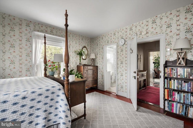 bedroom with ensuite bathroom and wood-type flooring