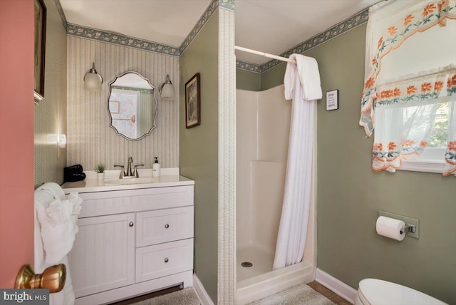 bathroom with curtained shower, vanity, and toilet