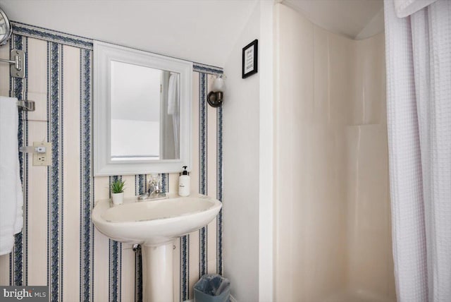 bathroom featuring lofted ceiling and walk in shower