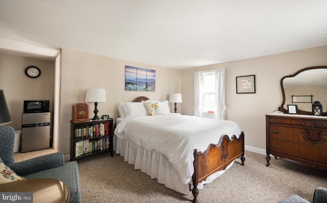 bedroom with stainless steel fridge and light carpet