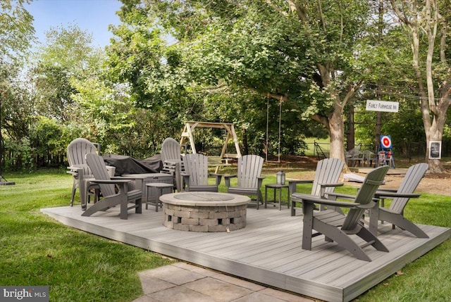 wooden terrace featuring a fire pit and a lawn