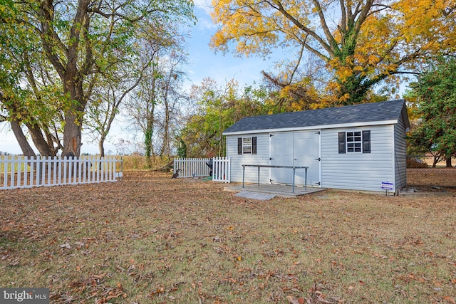 back of house with an outbuilding, a yard, and a patio area