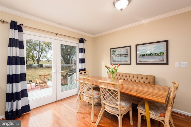 dining area with hardwood / wood-style floors, french doors, and crown molding