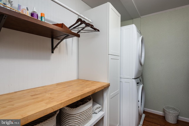 interior space featuring stacked washer / dryer, ornamental molding, cabinets, and dark hardwood / wood-style floors