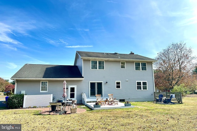 back of property featuring an outdoor fire pit, a lawn, and a patio area