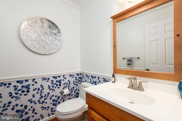 bathroom with vanity, toilet, and ornamental molding