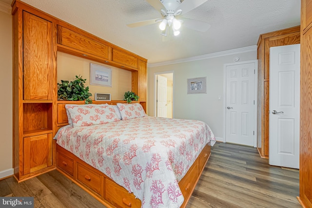 bedroom featuring dark wood-type flooring, ceiling fan, a textured ceiling, and ornamental molding