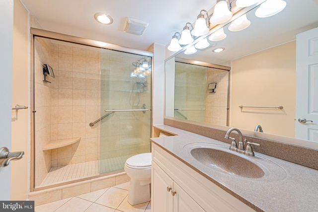 bathroom with toilet, vanity, tile patterned floors, and a shower with shower door