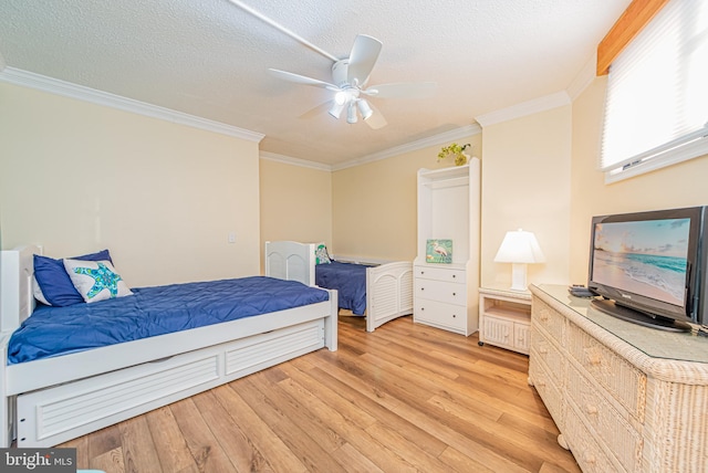 bedroom featuring ceiling fan, a textured ceiling, light hardwood / wood-style flooring, and crown molding