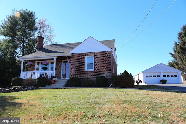 view of front of home featuring an outbuilding, a garage, a front yard, and a porch