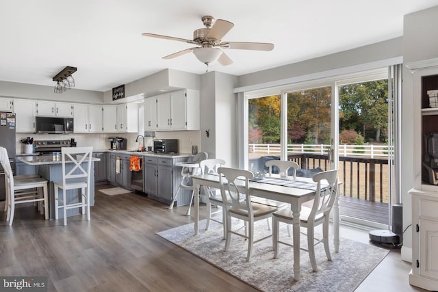 dining space featuring ceiling fan, sink, and dark hardwood / wood-style floors