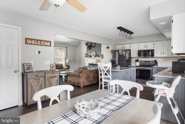 dining room with ceiling fan and dark hardwood / wood-style floors