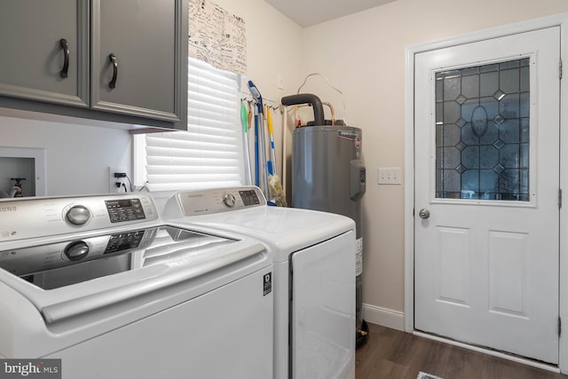 washroom with water heater, separate washer and dryer, dark hardwood / wood-style flooring, and cabinets