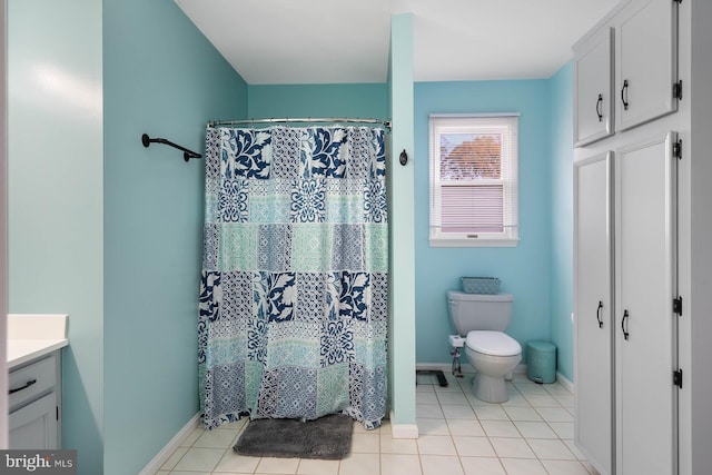 bathroom featuring curtained shower, tile patterned flooring, vanity, and toilet